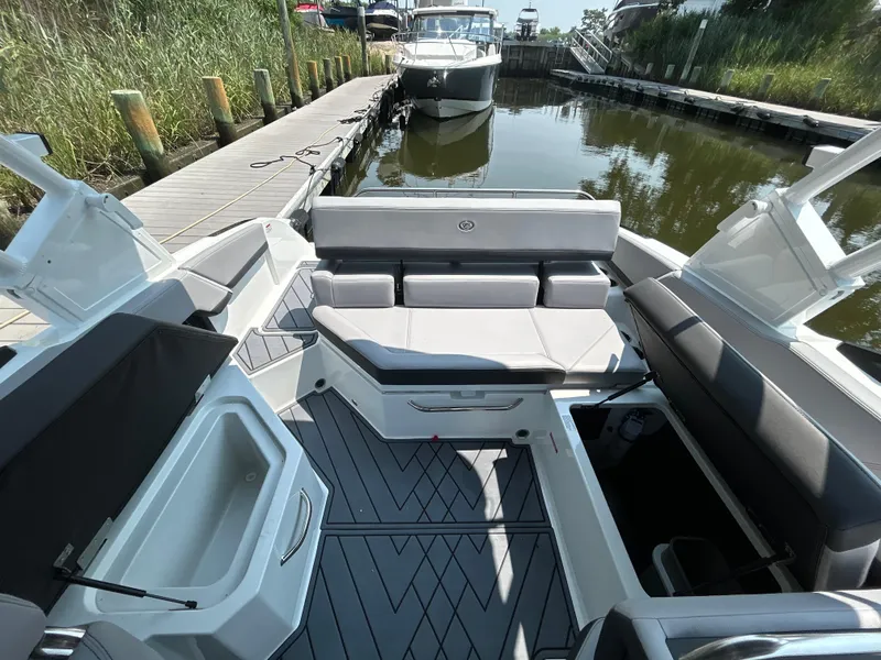 Slide: The Image of 2026 Cobalt R4 boat interior with sleek seating and storage, docked by a serene waterway. - 7