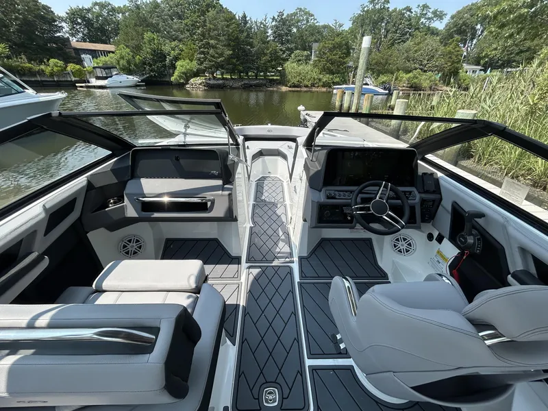 Slide: The Image of Interior of 2026 Cobalt R4 boat with modern seating and steering, docked by a scenic waterway. - 8