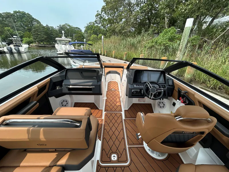 Slide: The Image of 2026 Cobalt R4 Outboard boat interior with tan seating, modern dashboard, and wood-patterned flooring. - 10