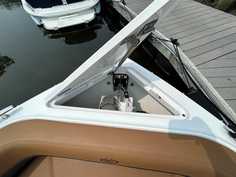 Slide: The Image of Open anchor compartment on 2026 Cobalt R4 Outboard boat, docked by wooden pier. - 16
