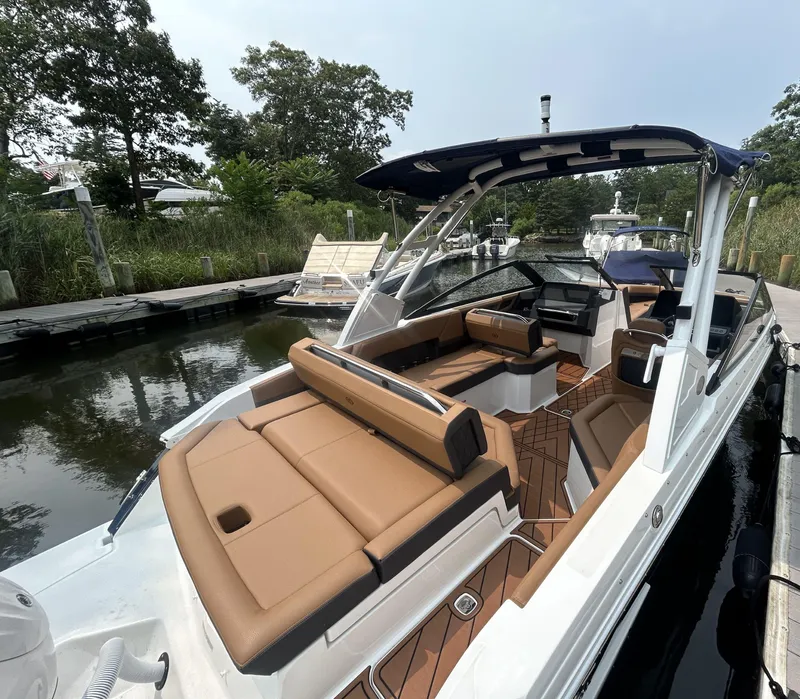 Slide: The Image of 2026 Cobalt R4 Outboard boat with tan seating, docked in a serene marina setting. - 5