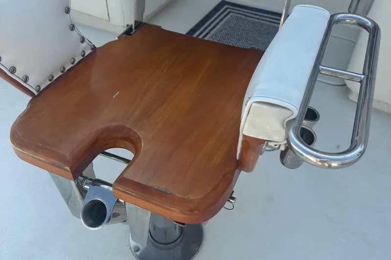Slide: The Image of Fishing chair on 1970 Hatteras 45 Convertible boat with wooden seat and metal armrest. - 12