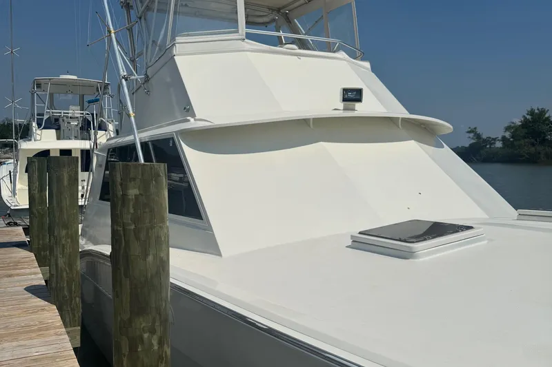 Slide: The Image of 1970 Hatteras 45 Convertible yacht docked at a marina on a sunny day. - 2