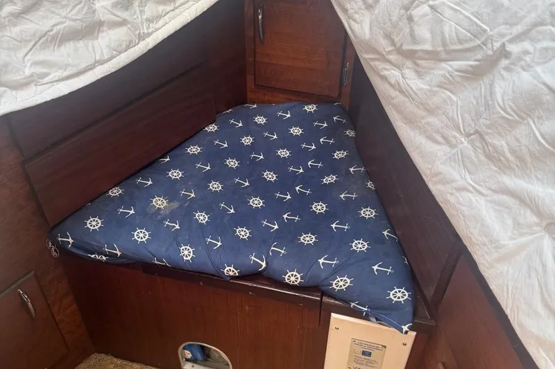 Slide: The Image of 1970 Hatteras 45 Convertible cabin with nautical-themed bedding and wooden interior. - 21