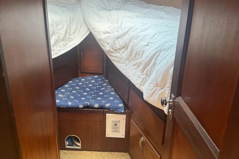 Slide: The Image of 1970 Hatteras 45 Convertible cabin interior with wooden finish and nautical-themed bedding. - 22