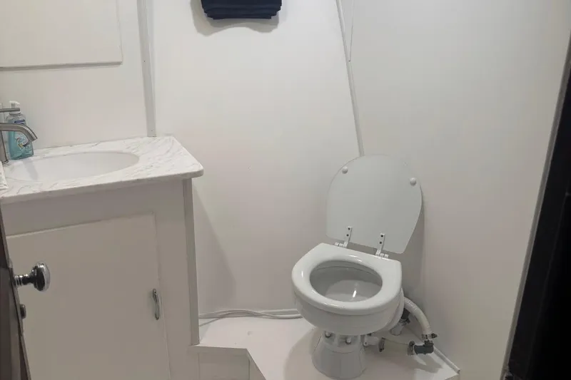 Slide: The Image of Bathroom interior of 1970 Hatteras 45 Convertible yacht, featuring toilet and sink. - 24