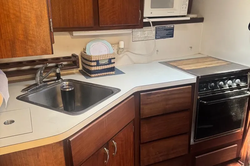 Slide: The Image of 1970 Hatteras 45 Convertible yacht kitchen with sink, stove, and microwave. - 26