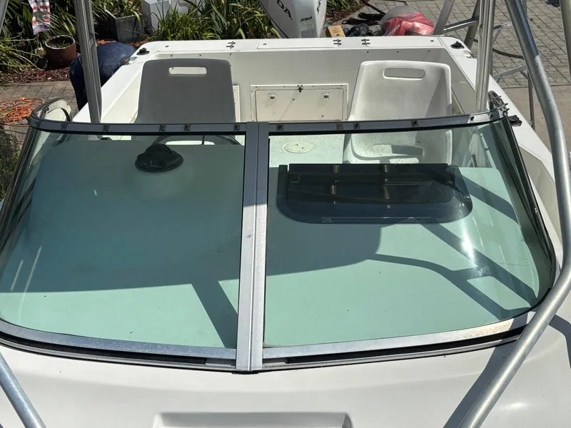 Slide: The Image of 2000 Hydra-Sports 230 Seahorse WA boat with dual seats and windshield, docked outdoors. - 3