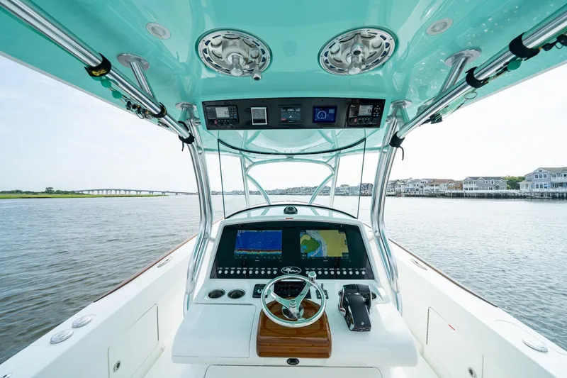 Slide: The Image of 2024 Valhalla Boatworks V-37 helm with advanced navigation system on calm waters. - 11
