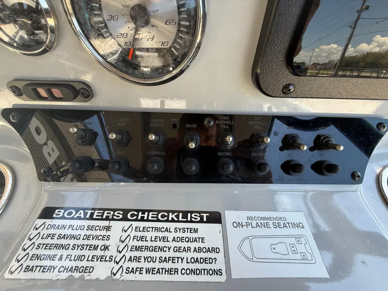 Slide: The Image of Control panel of 2022 Avid 23 Fusion Platinum boat with checklist and switches. - 15