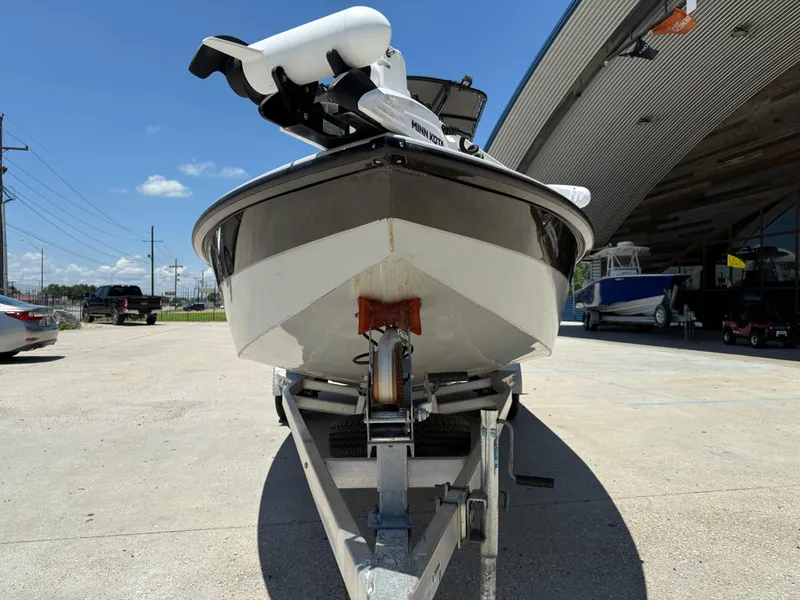 Slide: The Image of 2022 Avid 23 Fusion Platinum boat on trailer, parked outside a showroom. - 2