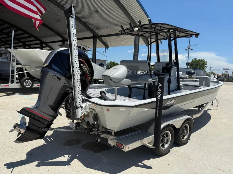 Slide: The Image of 2022 Avid 23 Fusion Platinum boat on trailer, under a canopy, with American flag. - 6