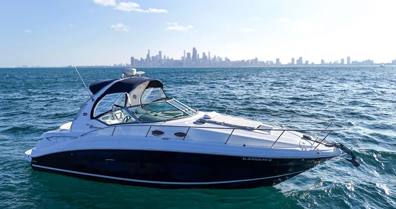 The Image of 2007 Sea Ray 320 Sundancer yacht on open water with city skyline in background. - 0