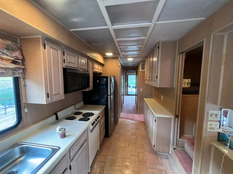 Slide: The Image of 1993 Sumerset houseboat kitchen with stove, microwave, and cabinets. - 15