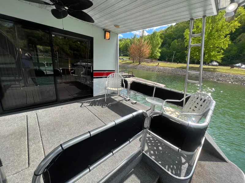 Slide: The Image of 1993 Sumerset houseboat deck with chairs, ladder, and scenic lake view. - 21