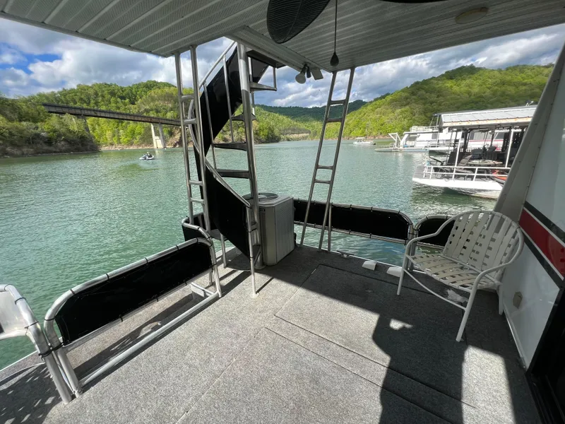 Slide: The Image of 1993 Sumerset houseboat deck with chairs, ladder, and scenic lake view. - 22