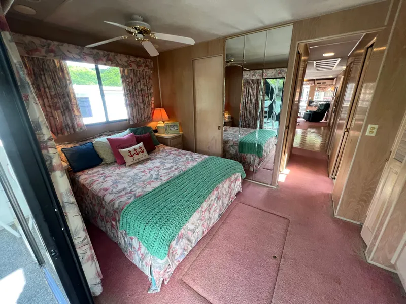 Slide: The Image of Cozy bedroom in a 1993 Sumerset houseboat with floral decor and mirrored closet. - 23