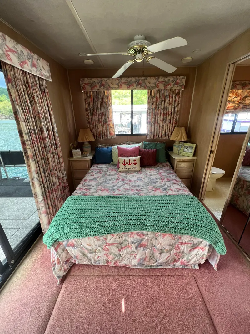 Slide: The Image of Cozy bedroom in a 1993 Sumerset houseboat with floral decor and lake view. - 27