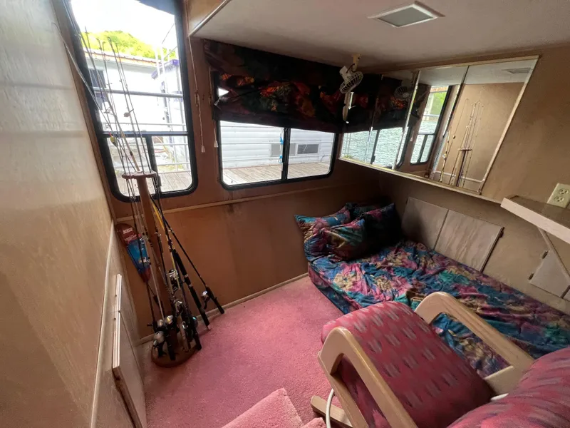 Slide: The Image of Cozy interior of a 1993 Sumerset houseboat with fishing rods and colorful decor. - 30