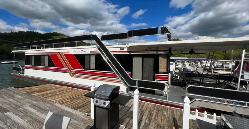 Slide: The Image of 1993 Sumerset houseboat docked with grill, under a partly cloudy sky. - 6