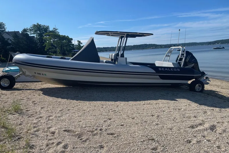 The Image of 2023 Sealegs 9M RIB amphibious boat on a sandy beach by the water. - 0
