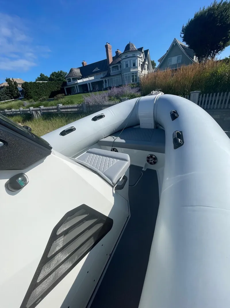 Slide: The Image of 2023 Sealegs 9M RIB boat docked near elegant coastal homes. - 3