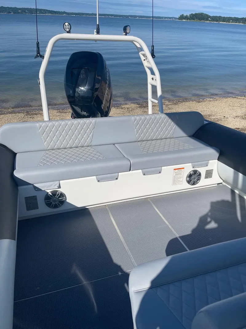 Slide: The Image of Interior of 2023 Sealegs 9M RIB with cushioned seating and scenic waterfront view. - 6