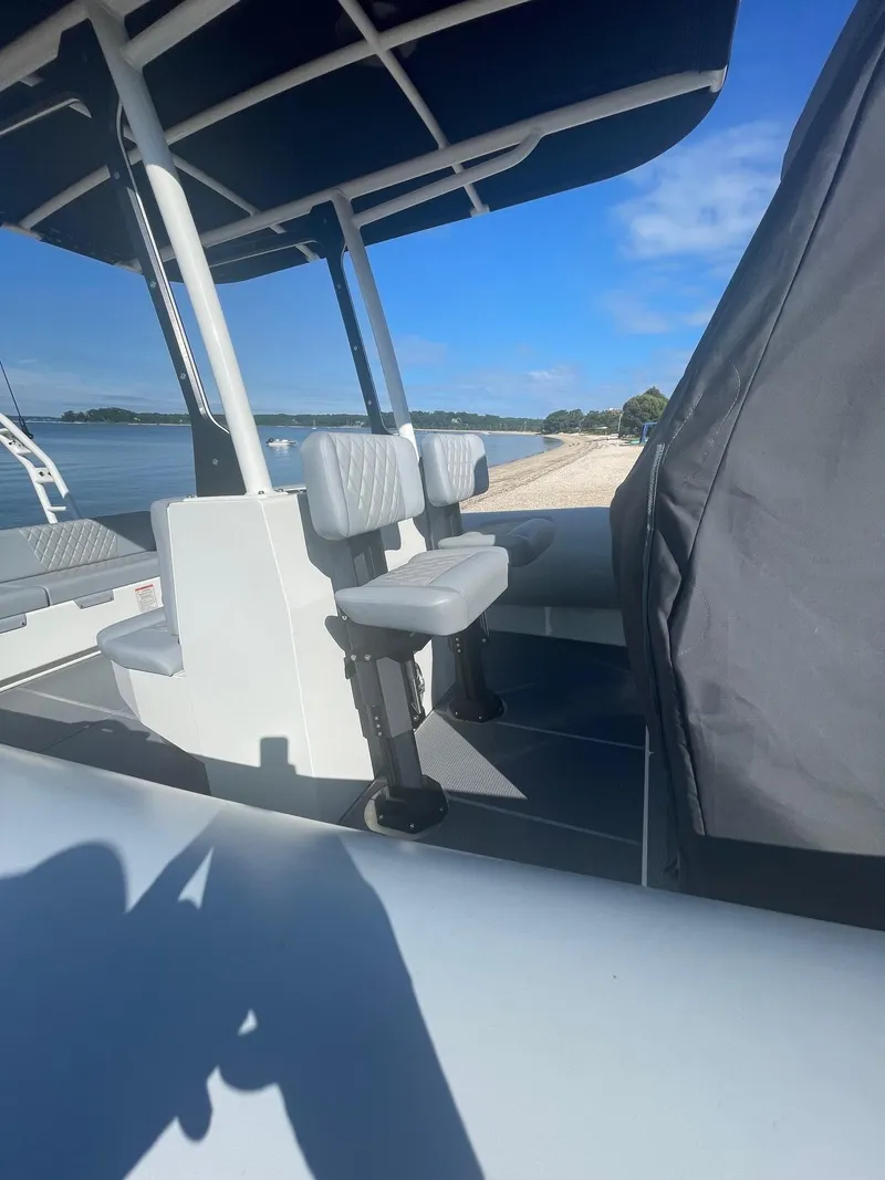 Slide: The Image of 2023 Sealegs 9M RIB boat interior with seating, near a sandy beach and calm waters. - 9