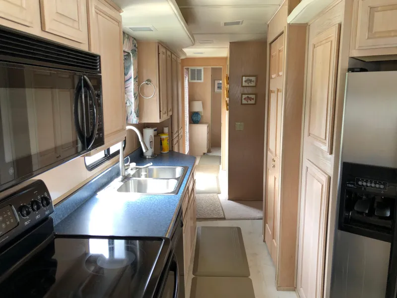 Slide: The Image of Interior of 1997 Sumerset 75' X 16' houseboat kitchen with modern appliances. - 11