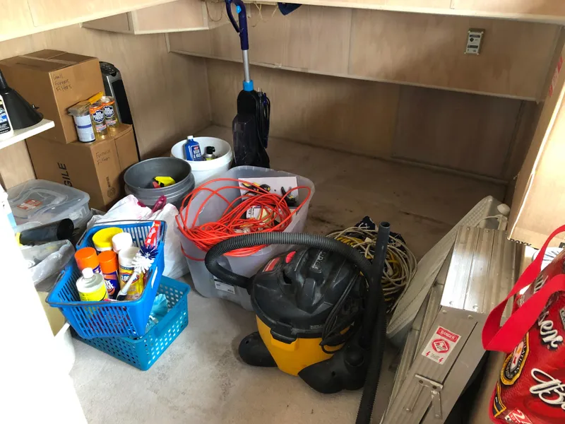 Slide: The Image of Storage area on a 1997 Sumerset houseboat with cleaning supplies and tools. - 13