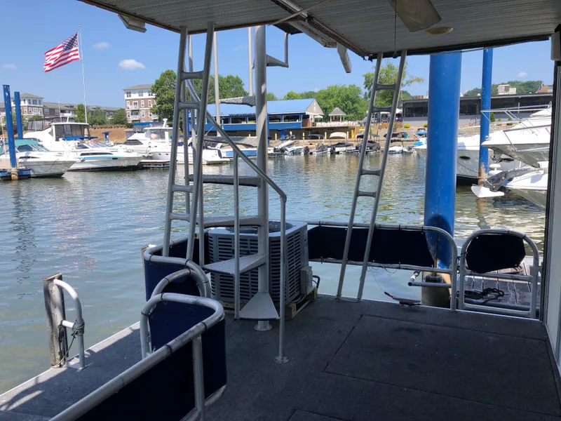 Slide: The Image of 1997 Sumerset 75' X 16' houseboat docked at marina with American flag. - 33
