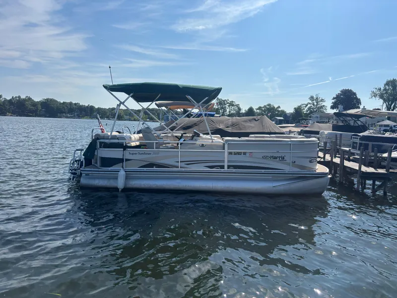 The Image of 2010 Harris FloteBote 200 Super Sunliner pontoon boat docked on a sunny lake. - 0