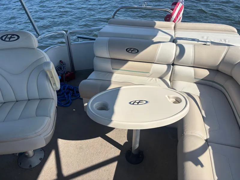 Slide: The Image of 2010 Harris FloteBote 200 Super Sunliner interior with beige seating and table on water. - 10