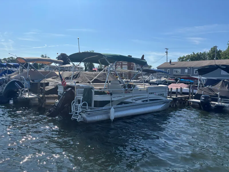 Slide: The Image of 2010 Harris FloteBote 200 Super Sunliner pontoon boat docked at marina under clear blue sky. - 8