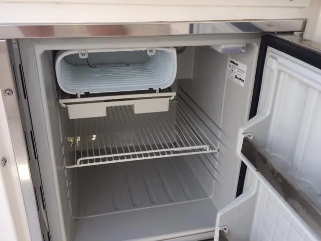 Slide: The Image of Open refrigerator inside 2007 Chaparral 275 SSi boat, showing empty shelves and ice compartment. - 15