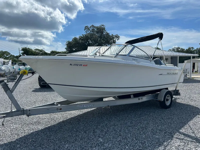 The Image of 2007 Sea Hunt Escape 220 DL boat on trailer under cloudy sky. - 1