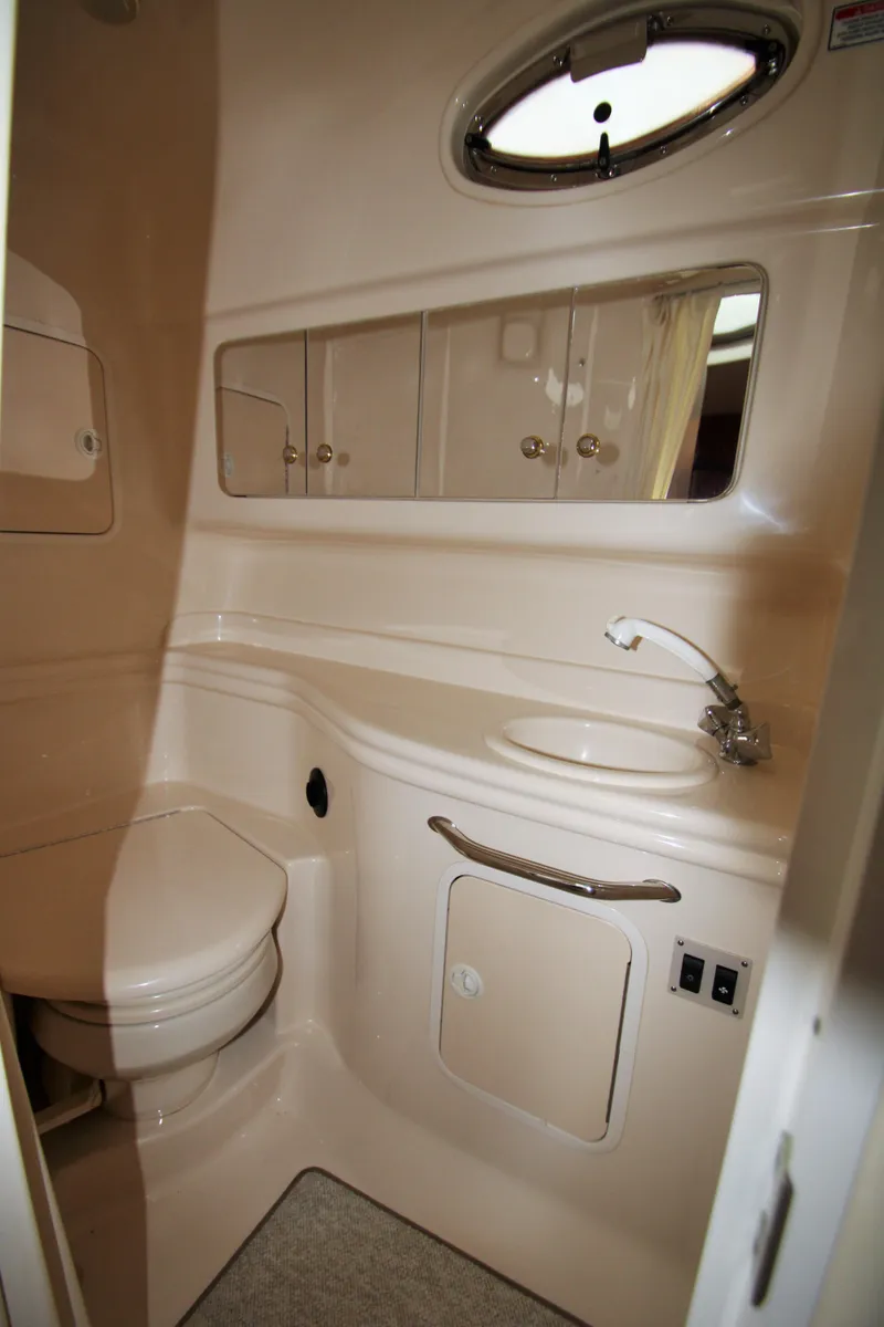 Slide: The Image of 2003 Sea Ray 320 Sundancer bathroom with sink, toilet, and storage cabinets. - 14