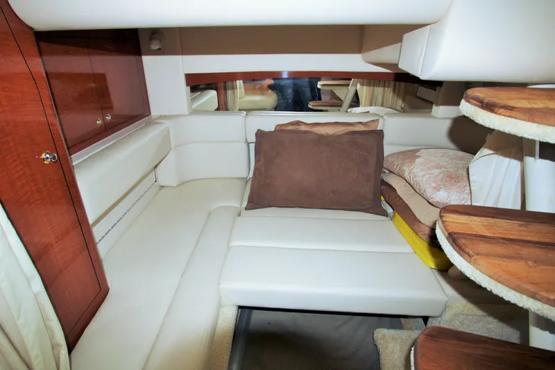 Slide: The Image of Interior cabin of 2003 Sea Ray 320 Sundancer with plush seating and wooden accents. - 18