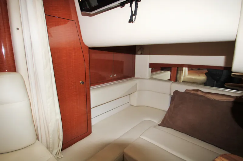 Slide: The Image of Interior of 2003 Sea Ray 320 Sundancer, featuring white leather seating and wooden cabinetry. - 19