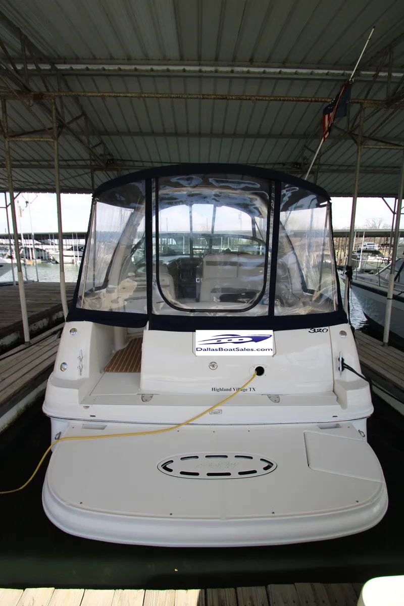 Slide: The Image of 2003 Sea Ray 320 Sundancer docked in a covered marina, rear view. - 23