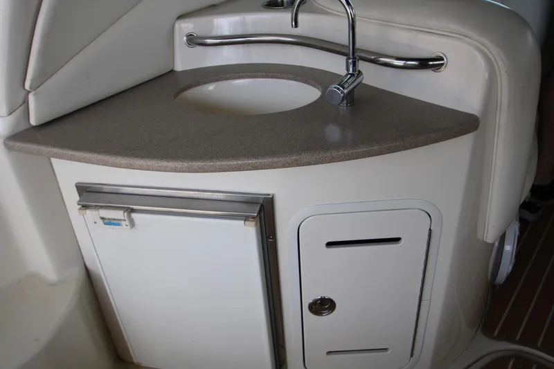 Slide: The Image of 2003 Sea Ray 320 Sundancer boat kitchenette with sink and mini fridge. - 24