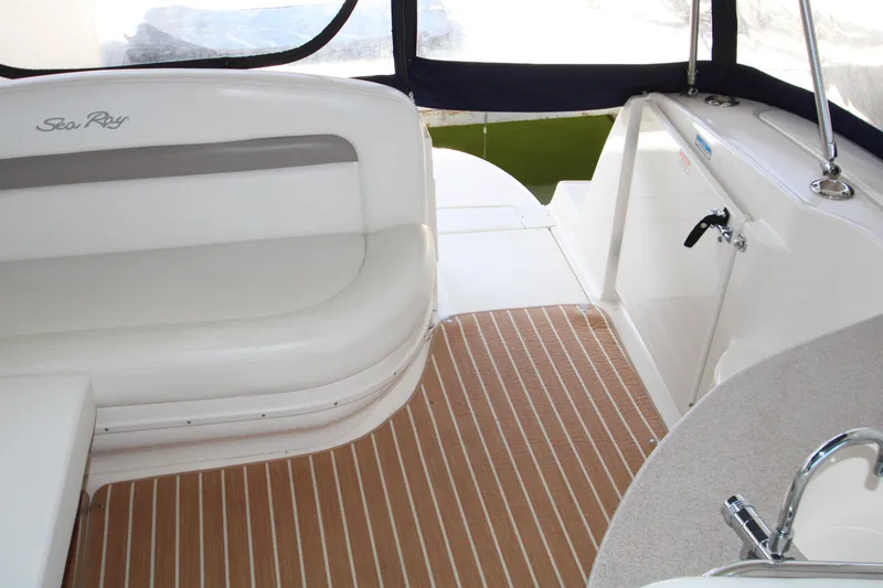 Slide: The Image of Interior of 2003 Sea Ray 320 Sundancer boat with white seating and wood-patterned flooring. - 27
