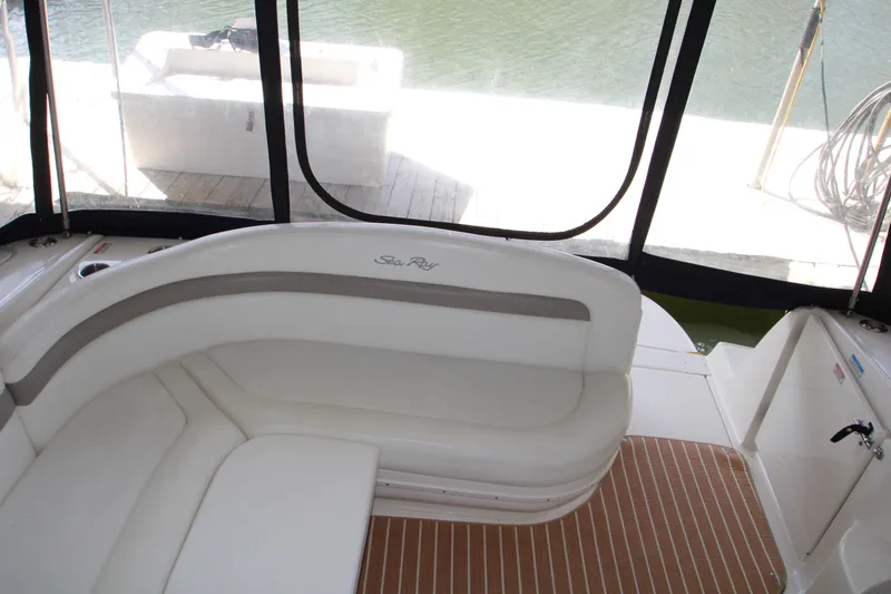 Slide: The Image of 2003 Sea Ray 320 Sundancer interior with white seating and wood-patterned flooring. - 29
