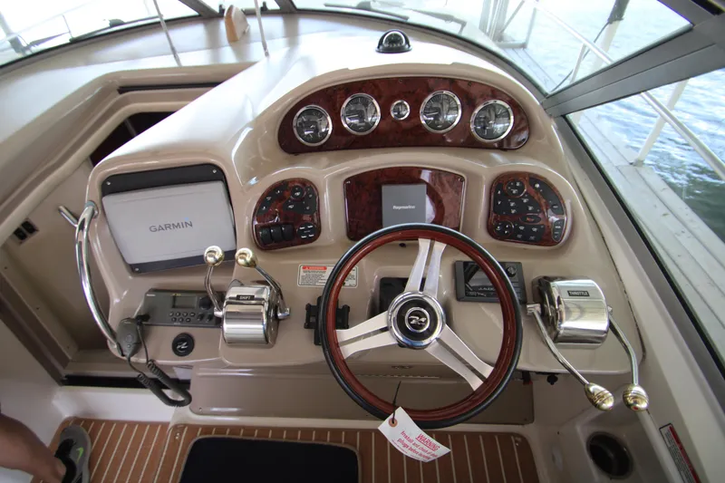 Slide: The Image of 2003 Sea Ray 320 Sundancer helm with Garmin navigation and wood-accented controls. - 34