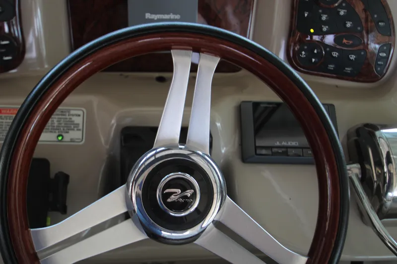 Slide: The Image of Steering wheel of 2003 Sea Ray 320 Sundancer boat, featuring wood and chrome accents. - 35