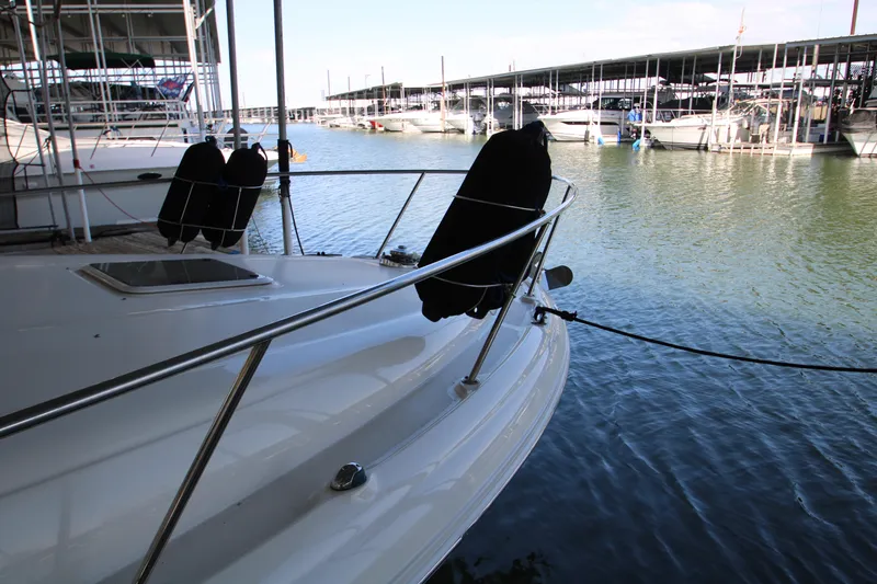 Slide: The Image of 2003 Sea Ray 320 Sundancer docked at marina, surrounded by calm water. - 45