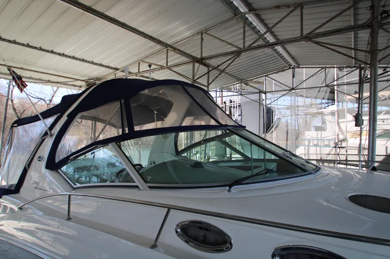 Slide: The Image of 2003 Sea Ray 320 Sundancer yacht under a covered dock, showcasing sleek design and canopy. - 46
