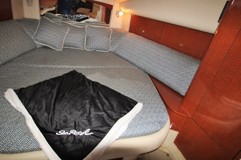 Slide: The Image of Interior cabin of 2003 Sea Ray 320 Sundancer with cozy bedding and wooden cabinetry. - 8