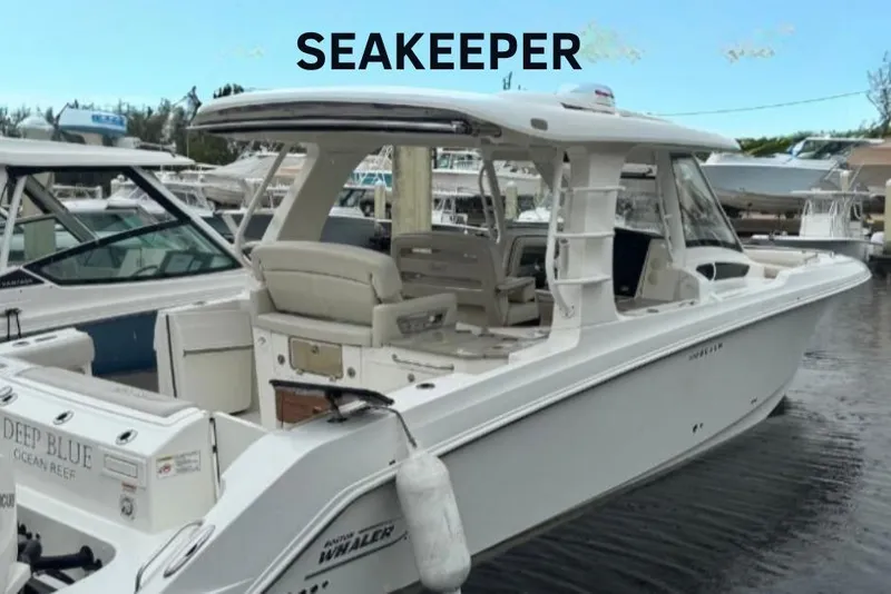 Slide: The Image of 2022 Boston Whaler 350 Realm boat docked, featuring spacious seating and sleek design. - 0