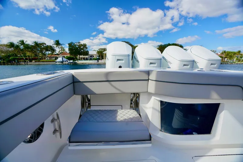 Slide: The Image of 2021 Valhalla Boatworks V46 with quad Mercury engines, luxurious seating, and scenic waterfront view. - 18